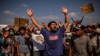 Refugees and migrants from the Moria camp protest near Mytilene on the Greek island of Lesbos, on September 12, 2020, a few days after a fire destroyed the Moria refugee camp. - Tension was simmering on September 12 on Greece's Lesbos island as thousands of asylum seekers remained homeless four days after Europe's largest migrant camp was destroyed by fire. Round-the-clock efforts to find temporary shelter for over 11,000 people including thousands of children were still inadequate, rights groups said as local authorities continued to oppose camp reconstruction plans. (Photo by ANGELOS TZORTZINIS / AFP) (Photo by ANGELOS TZORTZINIS/AFP via Getty Images)